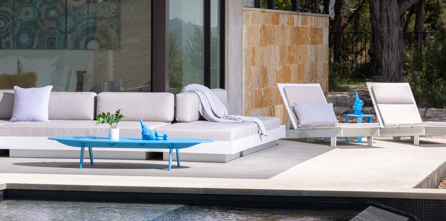 platform one sofas and 2 lollygagger chaises with various pillows and throws along side a pool
