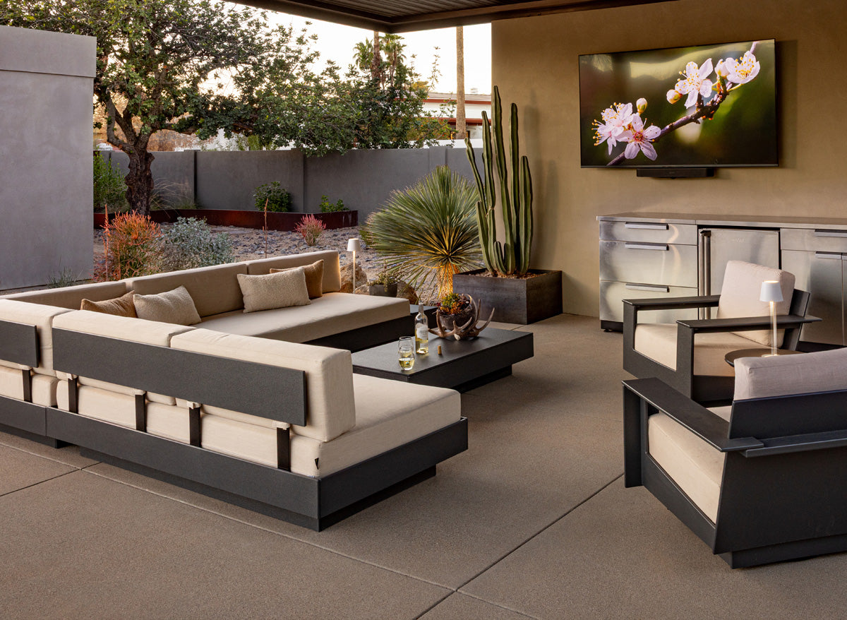 two platform one sofas arranged in an "L" and a pair of nisswa lounge chairs on a stone patio.
