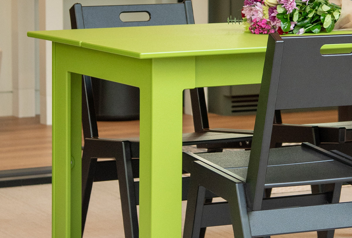 a leaf green fresh air table with two black alfresco dining chairs.