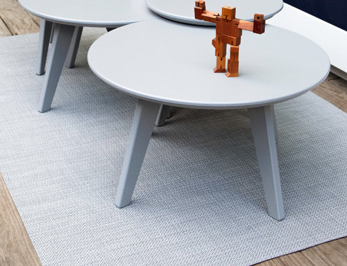 a collection of satellite end and side tables arranged to make a larger cocktail table.