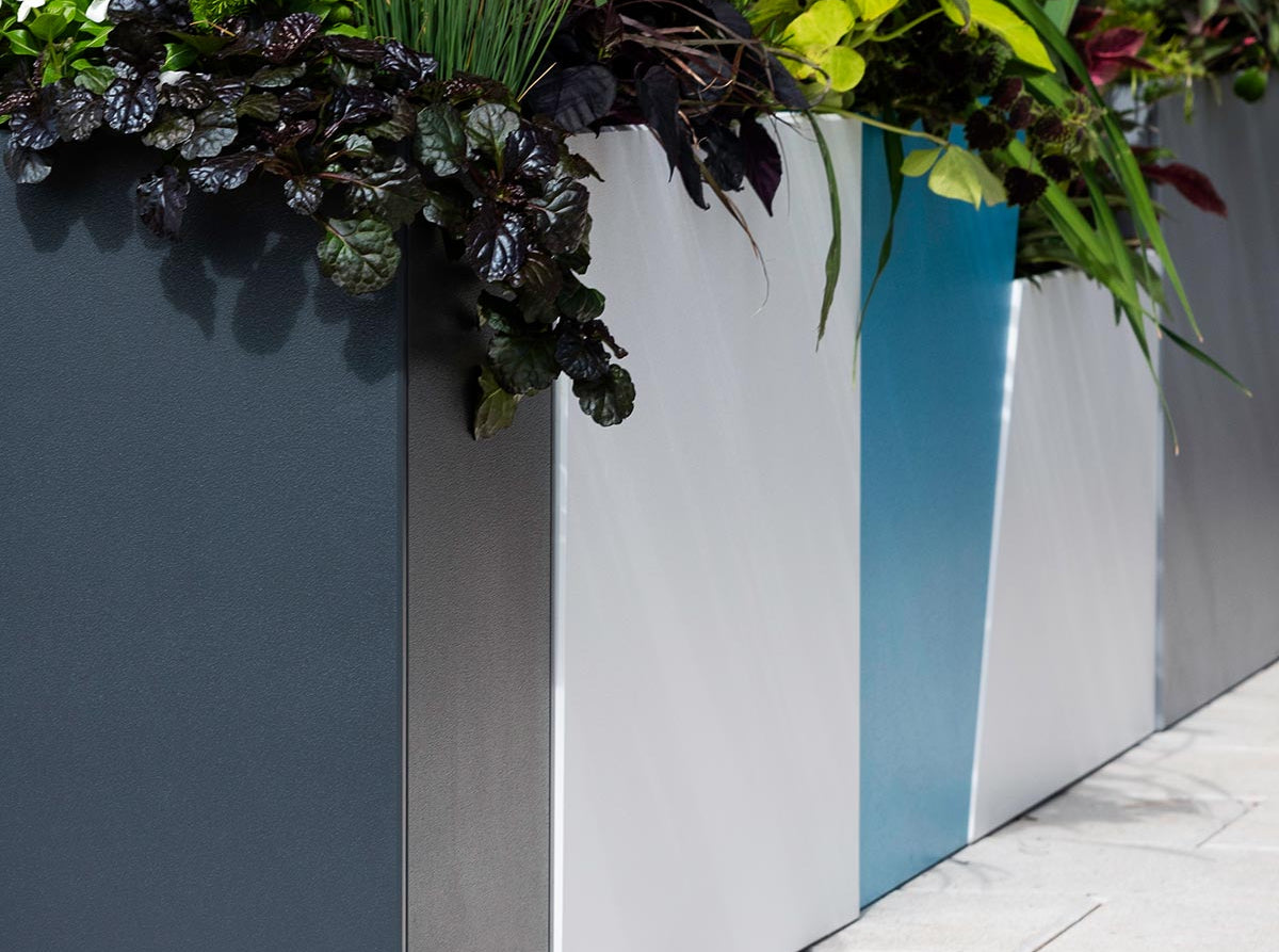 various tessellate planters arranged in an "L" shape with plants.