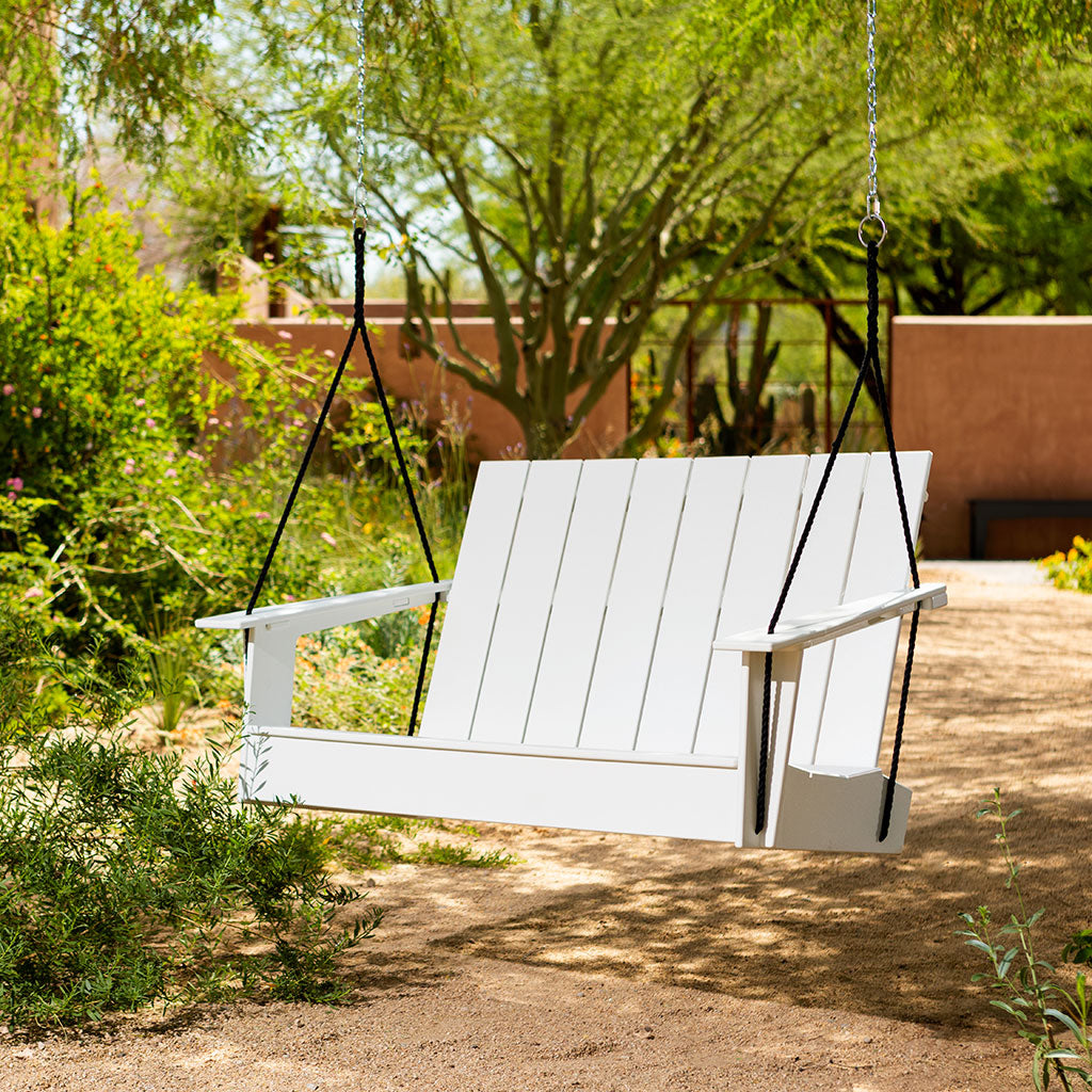 white adirondack porch swing in yard