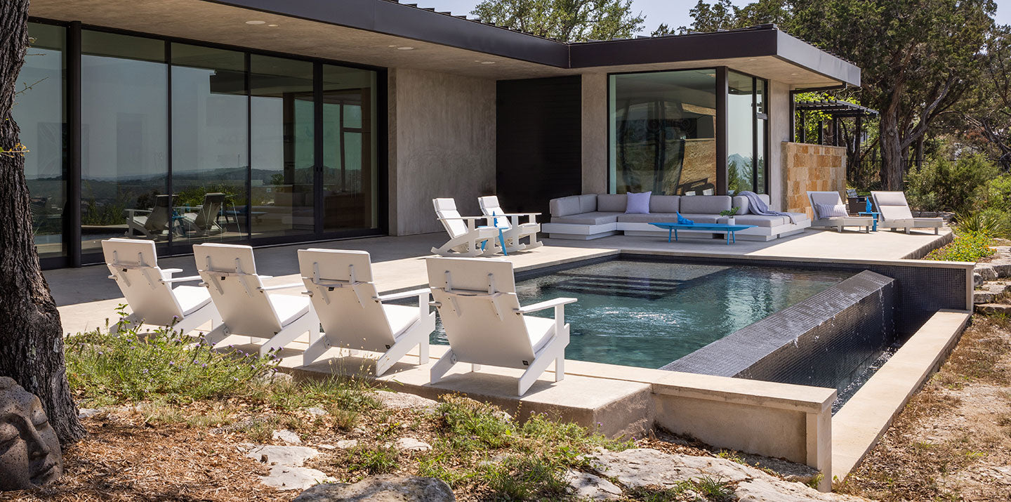 patio with infinity pool surrounded by white outdoor furniture chairs and sofas - austin texas