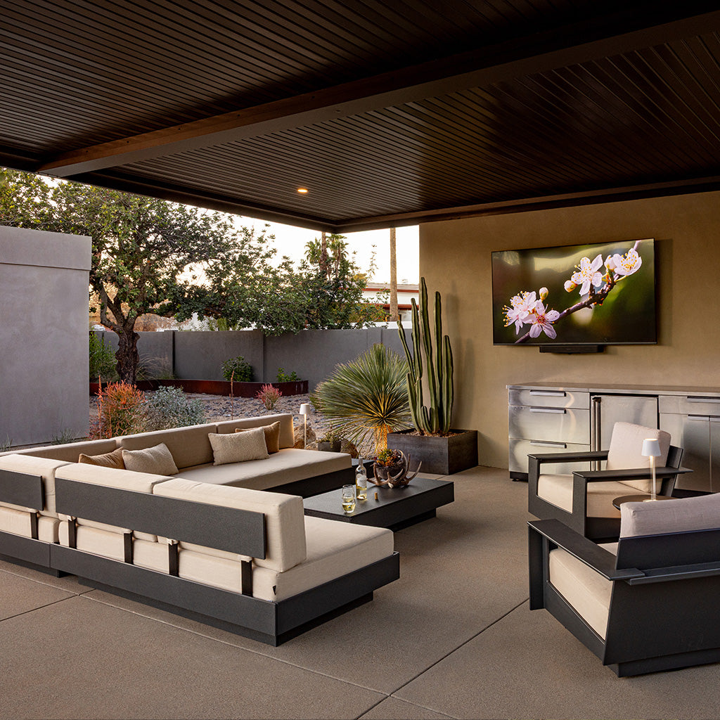 A Platform One sofa setup with a Platform One Coffee Table and two Nisswa Swivel lounge chairs in a covered outdoor seating area.