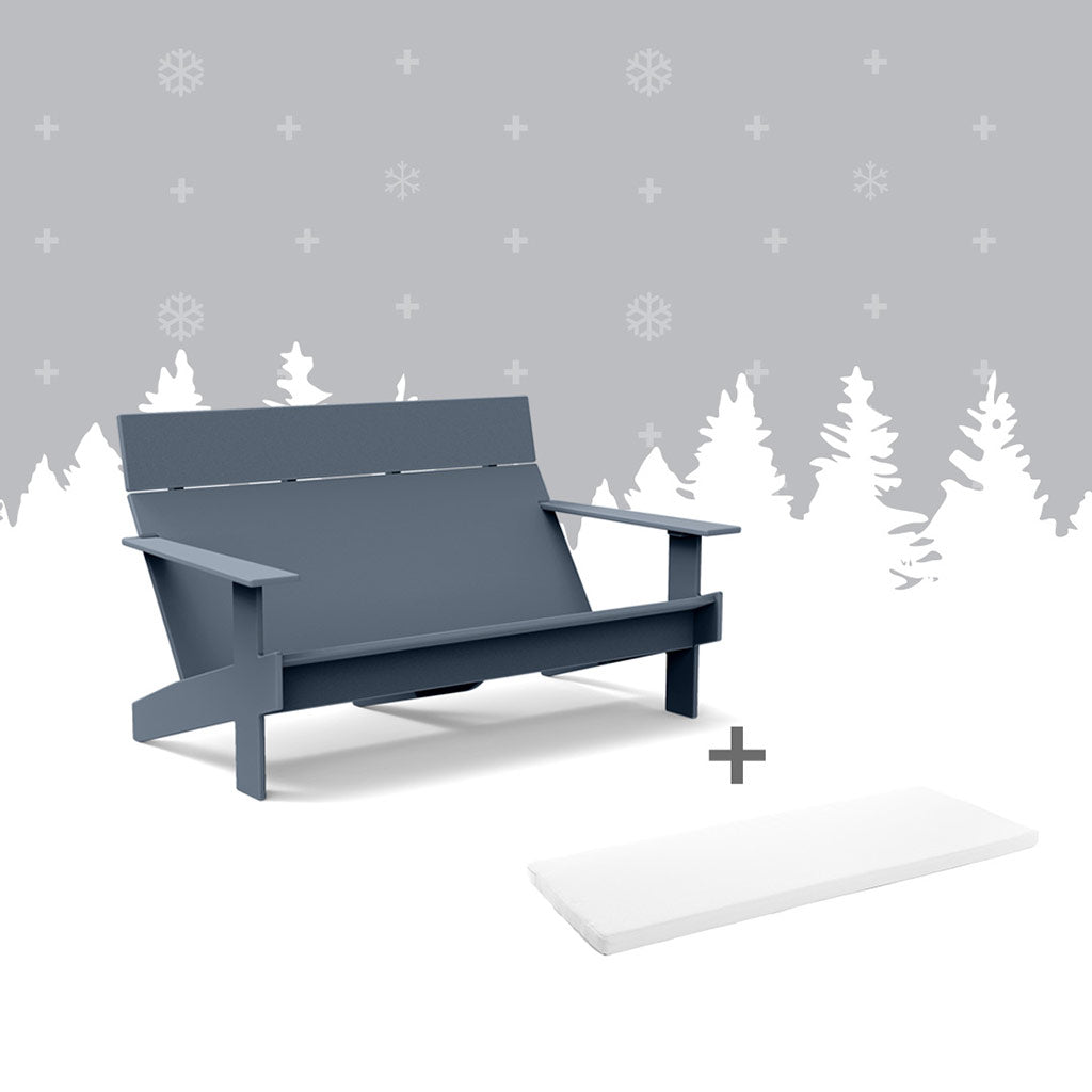 ash blue lollygagger sofa and a white sofa cushion against grey forest background.